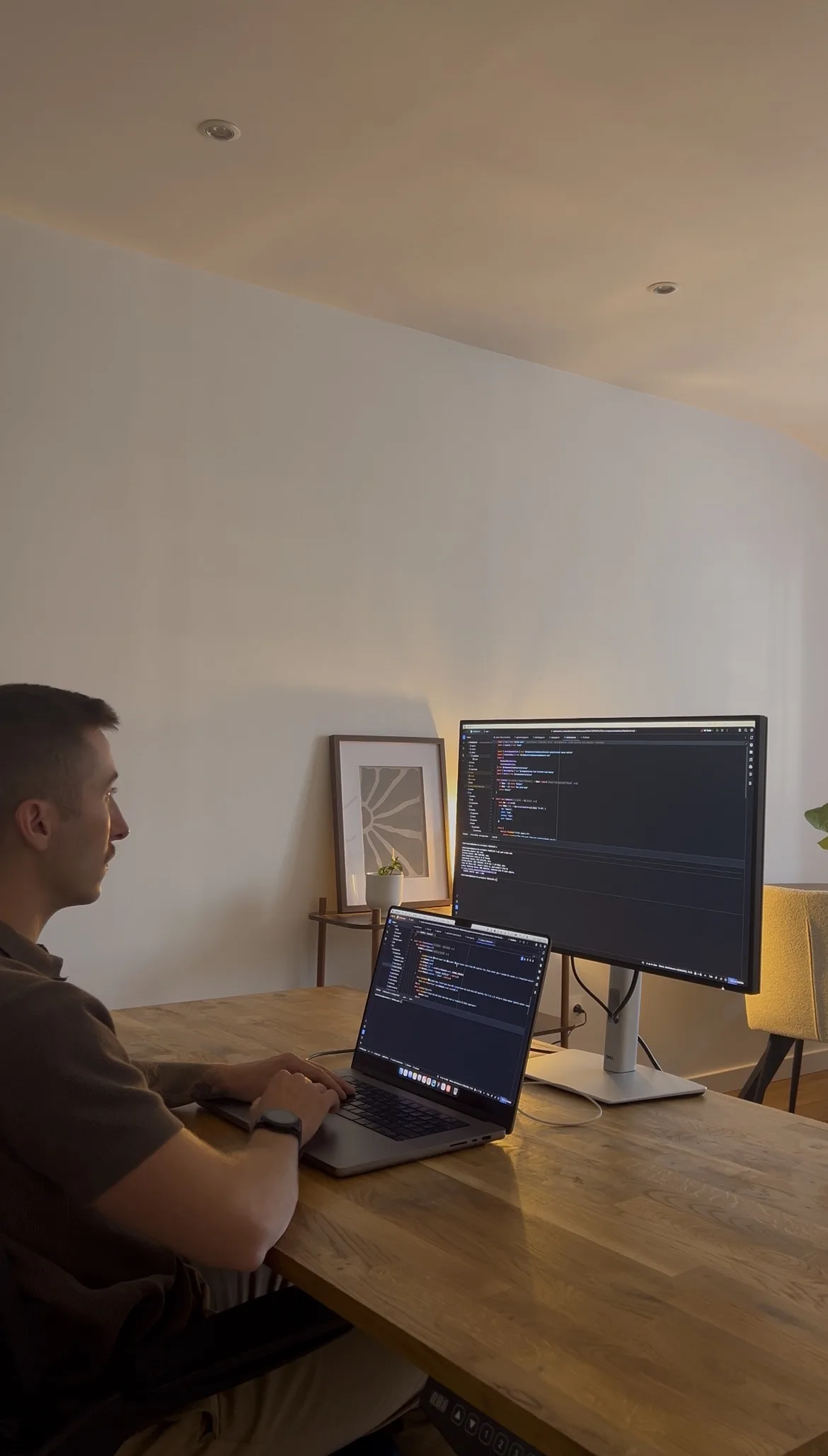 Dimitri Dumont code sur son ordinateur portable, face à un second écran